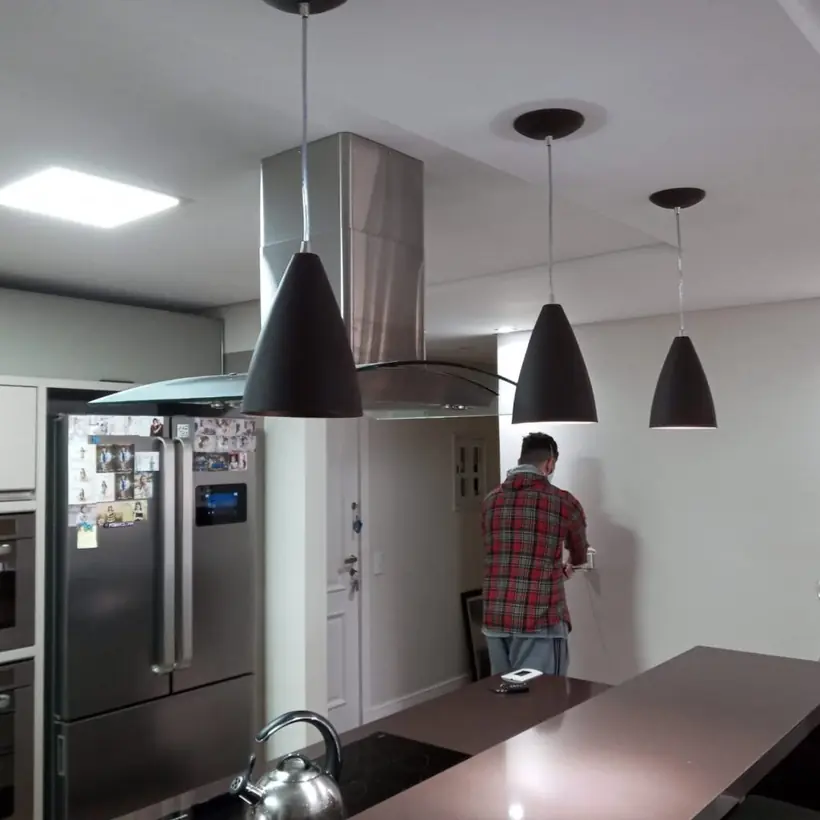 Três pendentes alinhados sobre a bancada da cozinha